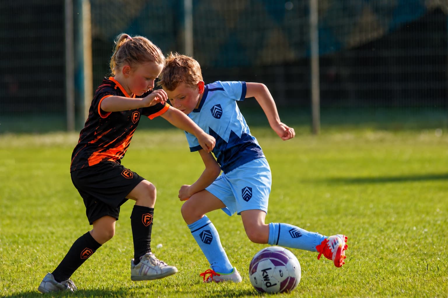 Kids in Forge SC and Elevate SC kits battle for the ball.
